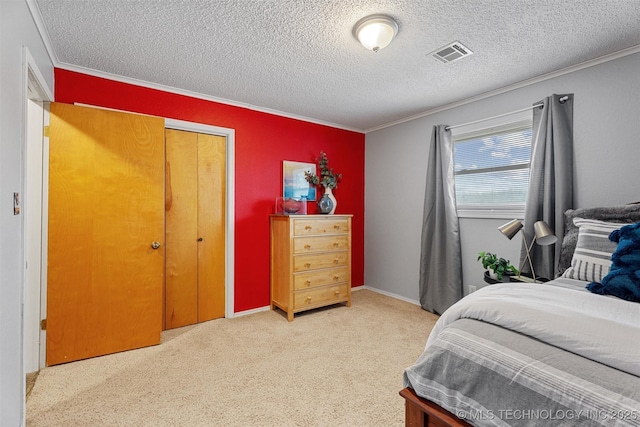 bedroom featuring visible vents, light colored carpet, ornamental molding, a closet, and a textured ceiling