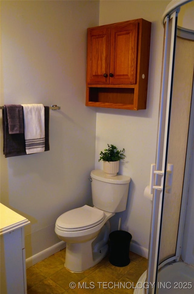 full bath featuring toilet, vanity, and baseboards