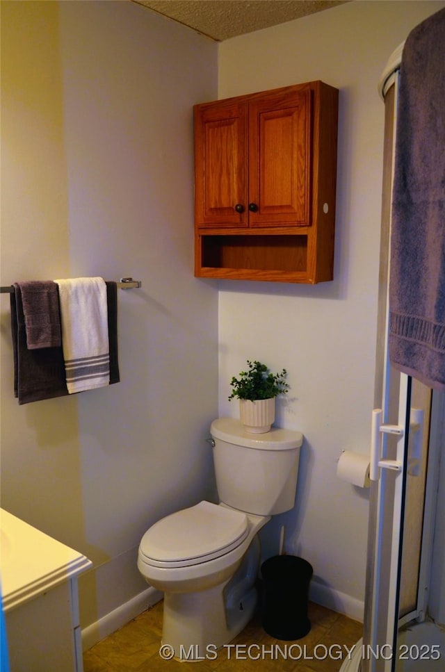 bathroom featuring vanity, toilet, baseboards, and a textured ceiling