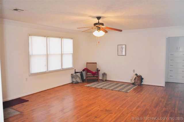 unfurnished room featuring visible vents, baseboards, a ceiling fan, and wood finished floors