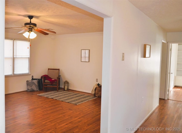 interior space featuring wood finished floors, baseboards, and a textured ceiling