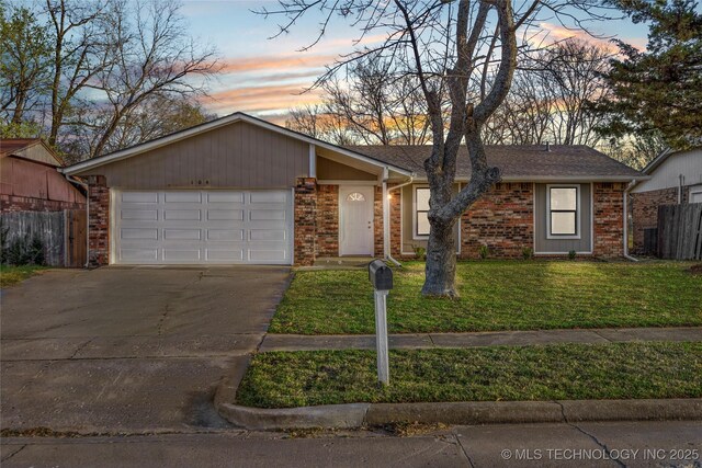 view of front of house featuring fence, concrete driveway, an attached garage, a front yard, and brick siding