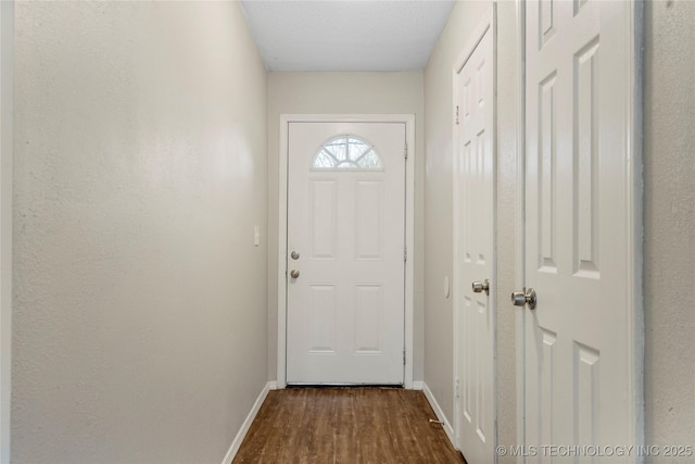 doorway to outside with dark wood finished floors and baseboards