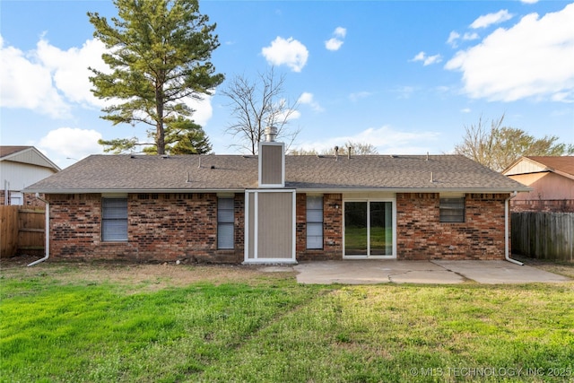 rear view of house featuring a yard, brick siding, a patio, and fence