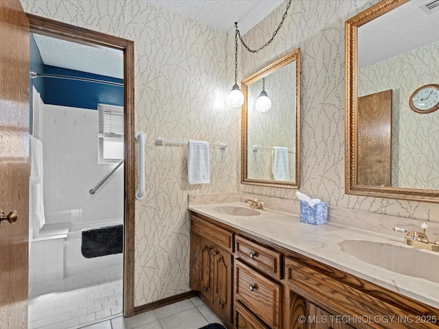 bathroom with a sink, a textured ceiling, and wallpapered walls