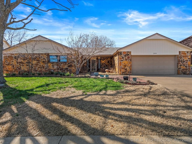 view of front facade featuring stone siding, driveway, and a garage