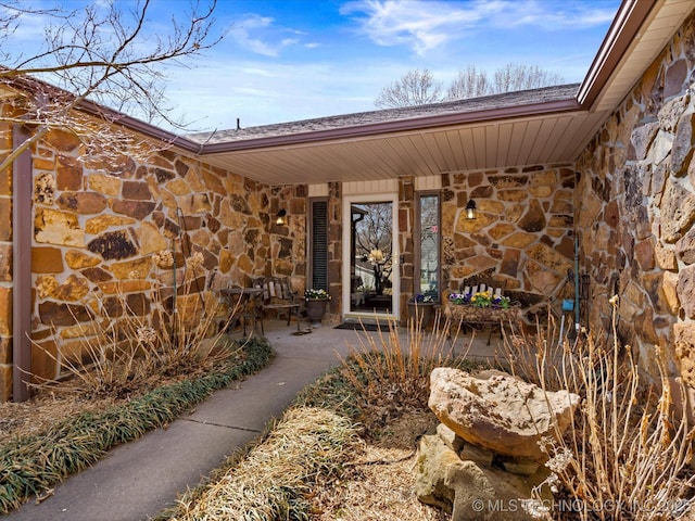 property entrance with a patio and stone siding