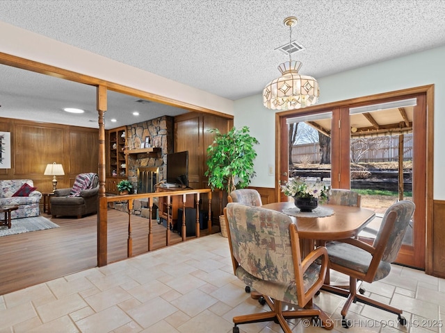 dining area with visible vents, wood walls, and wainscoting