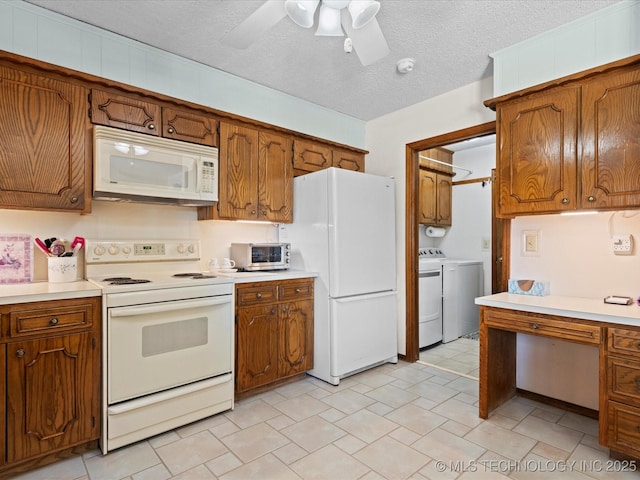 kitchen featuring brown cabinetry, independent washer and dryer, and white appliances