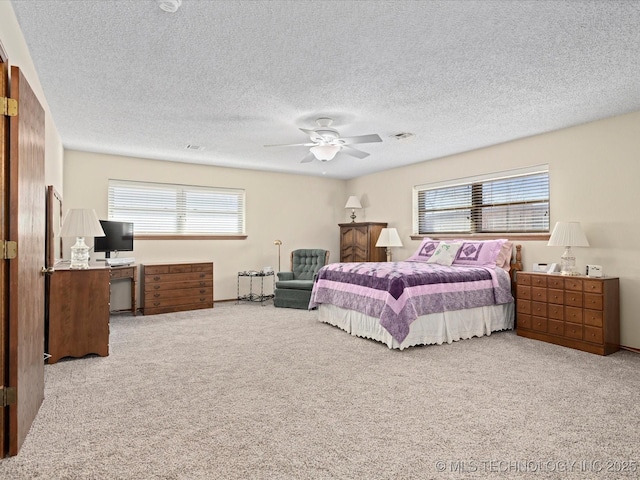 carpeted bedroom with multiple windows, a textured ceiling, and a ceiling fan