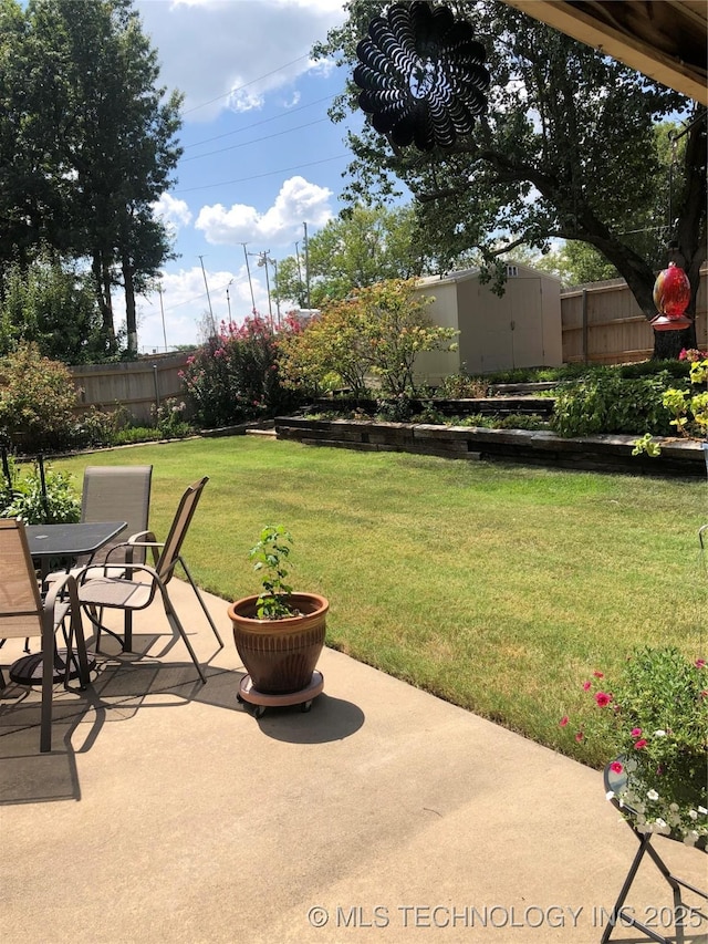 view of yard with a storage unit, a patio, a fenced backyard, an outdoor structure, and outdoor dining area