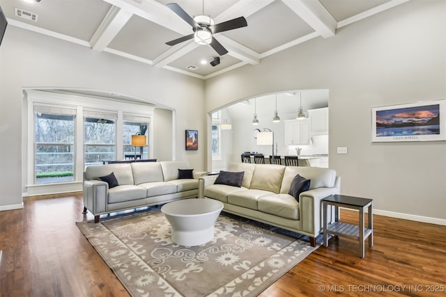 living room with visible vents, ceiling fan, baseboards, dark wood finished floors, and arched walkways