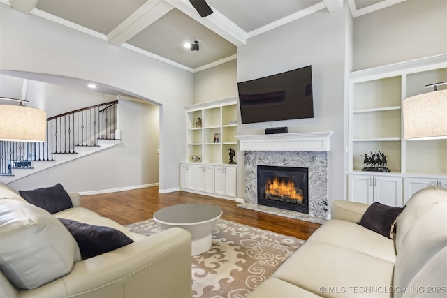 living room with stairway, ornamental molding, wood finished floors, and a premium fireplace