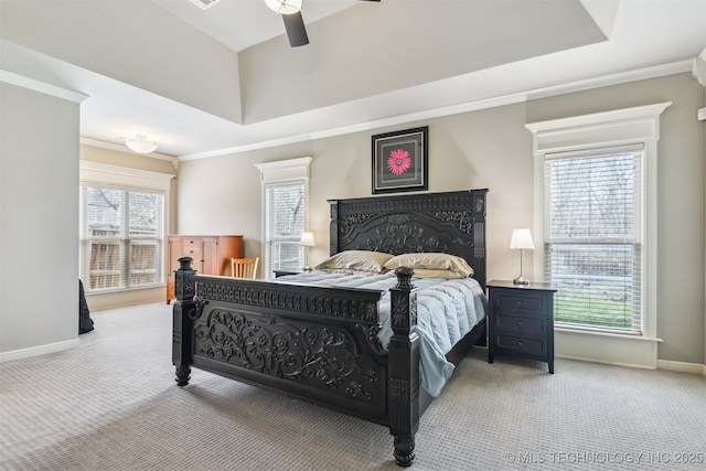 carpeted bedroom featuring a ceiling fan, baseboards, ornamental molding, and a tray ceiling
