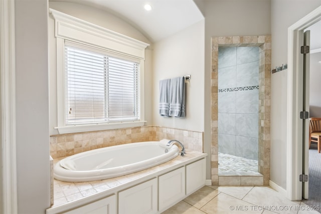 bathroom with a bath, tile patterned floors, tiled shower, and lofted ceiling