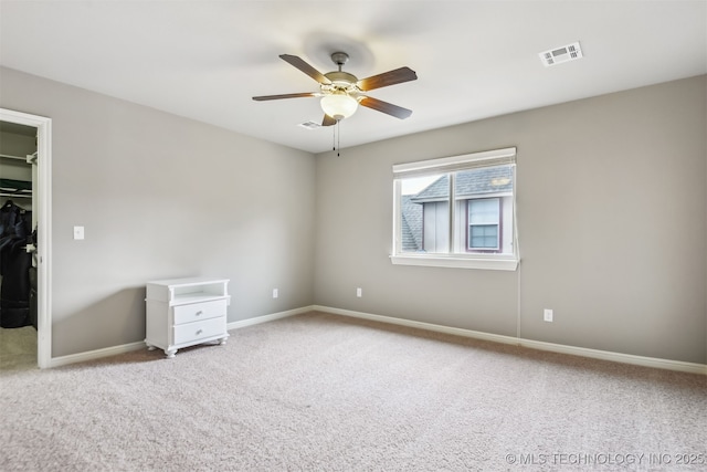 unfurnished bedroom featuring visible vents, baseboards, a walk in closet, and carpet flooring