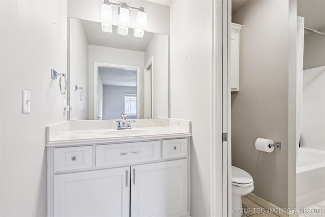 bathroom with vanity, toilet, washtub / shower combination, and baseboards