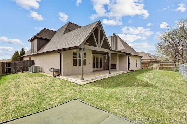 back of house with a fenced backyard, stucco siding, and a yard