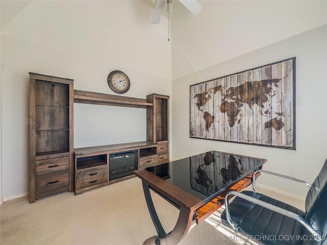 carpeted home office with a high ceiling, a ceiling fan, and baseboards