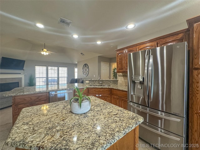 kitchen featuring visible vents, a peninsula, a sink, appliances with stainless steel finishes, and open floor plan