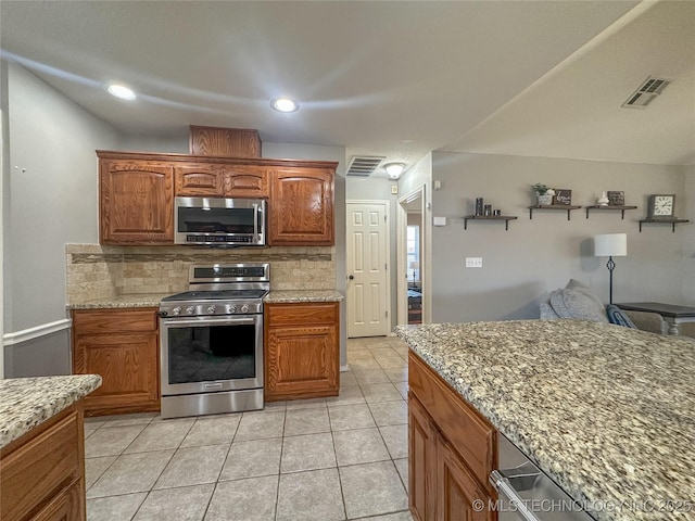 kitchen with light stone counters, visible vents, appliances with stainless steel finishes, and decorative backsplash