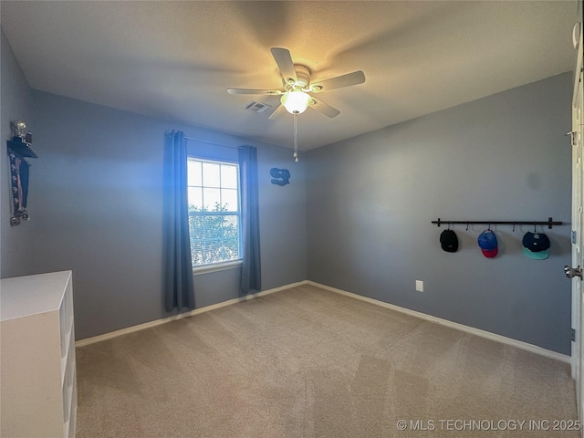 empty room with visible vents, baseboards, carpet flooring, and a ceiling fan