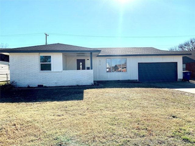 single story home featuring an attached garage, a shingled roof, a front lawn, concrete driveway, and brick siding