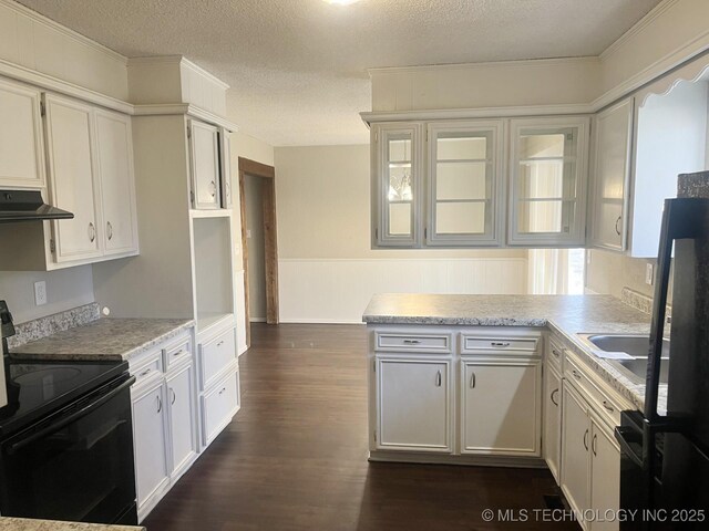 kitchen with black range with electric cooktop, under cabinet range hood, light countertops, a textured ceiling, and dark wood-style flooring