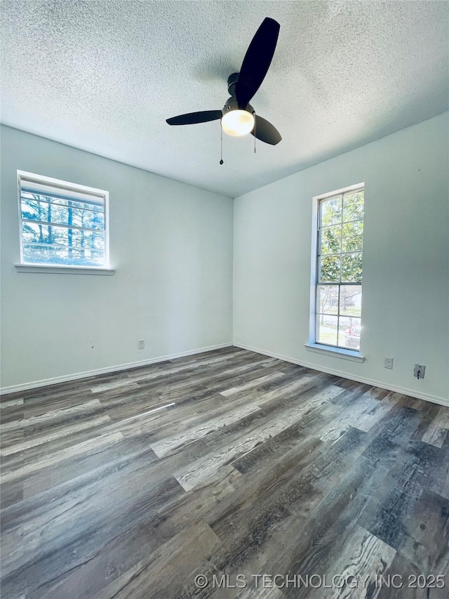 spare room featuring a ceiling fan, wood finished floors, baseboards, and a textured ceiling