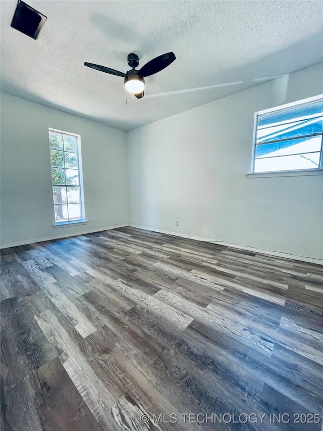 unfurnished room featuring a textured ceiling, wood finished floors, baseboards, and ceiling fan