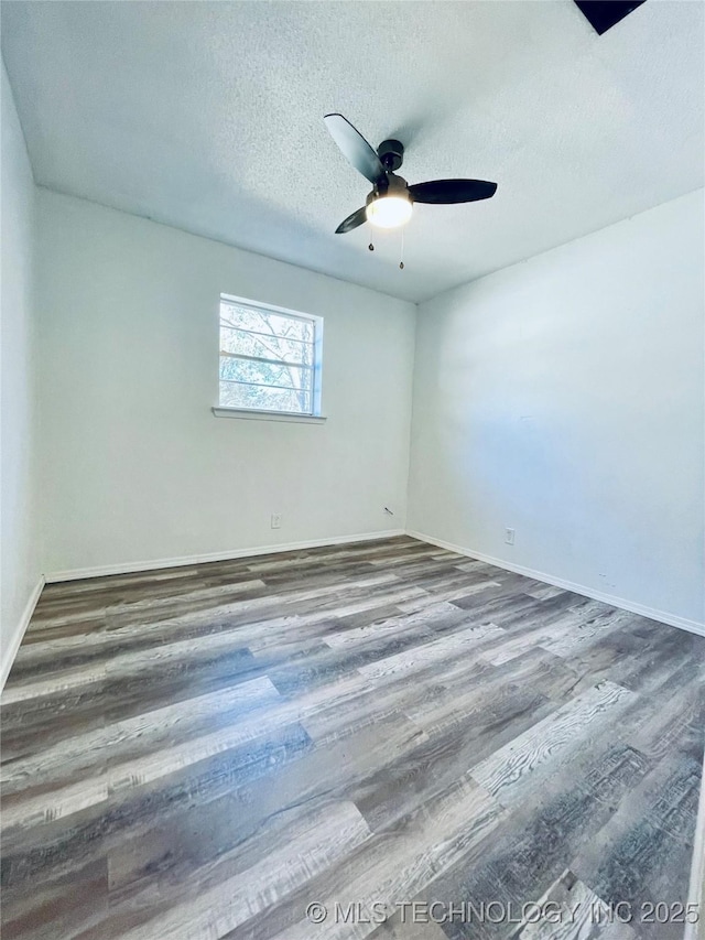 spare room featuring baseboards, a textured ceiling, a ceiling fan, and wood finished floors