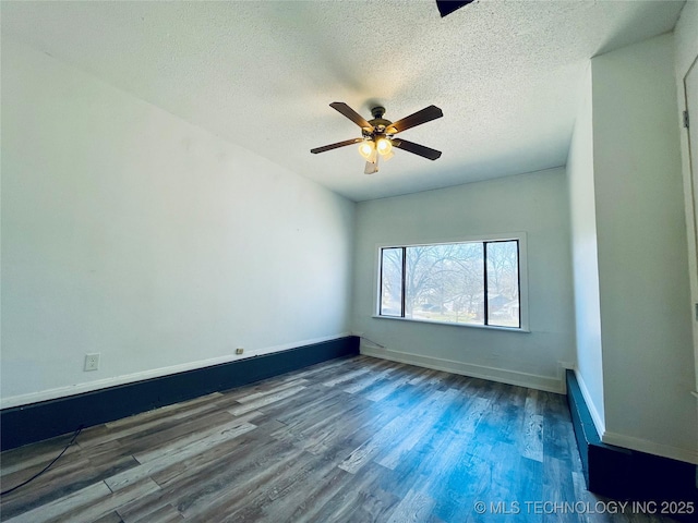 unfurnished room with a textured ceiling, wood finished floors, baseboards, and ceiling fan