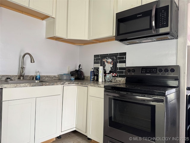 kitchen with a sink, decorative backsplash, appliances with stainless steel finishes, and white cabinets