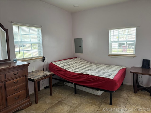 bedroom featuring electric panel and baseboards