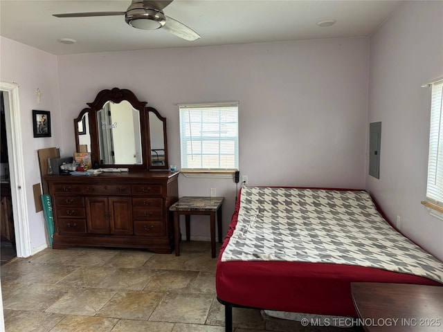 bedroom featuring stone finish floor, electric panel, and ceiling fan