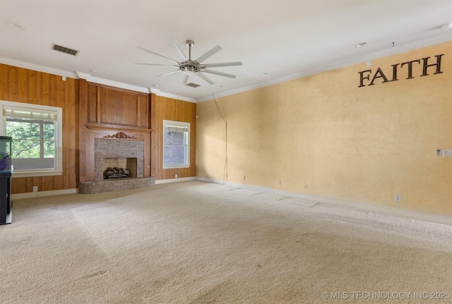 unfurnished living room featuring visible vents, a ceiling fan, carpet floors, a fireplace, and crown molding