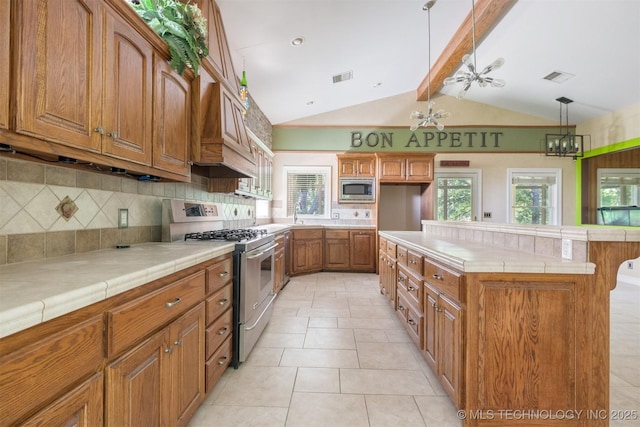 kitchen featuring tile countertops, brown cabinetry, visible vents, and stainless steel appliances