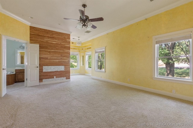 carpeted empty room featuring ceiling fan, visible vents, baseboards, and ornamental molding