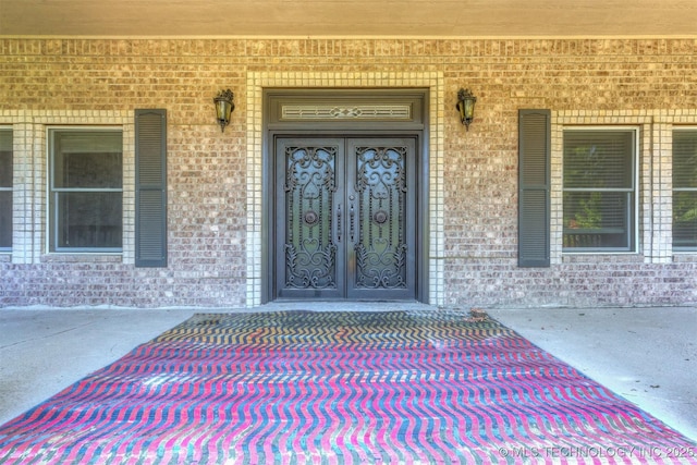 view of exterior entry with brick siding