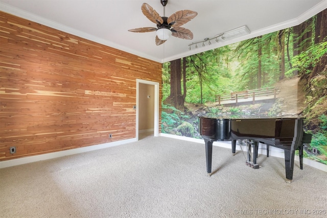 unfurnished room with wooden walls, a ceiling fan, carpet, and ornamental molding