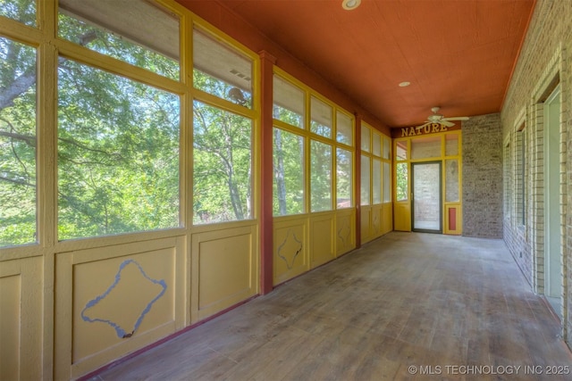 unfurnished sunroom featuring a healthy amount of sunlight and ceiling fan