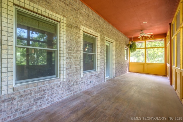 unfurnished sunroom with ceiling fan