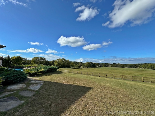 view of yard featuring a rural view and fence