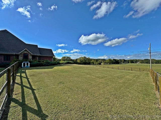 view of yard featuring a rural view and fence