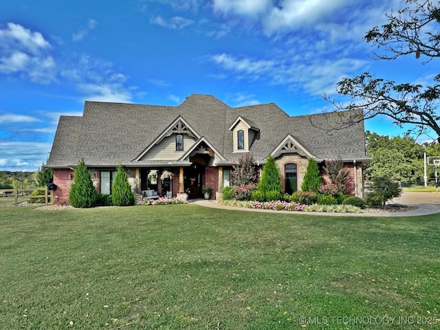 craftsman-style home with brick siding, a front lawn, and roof with shingles