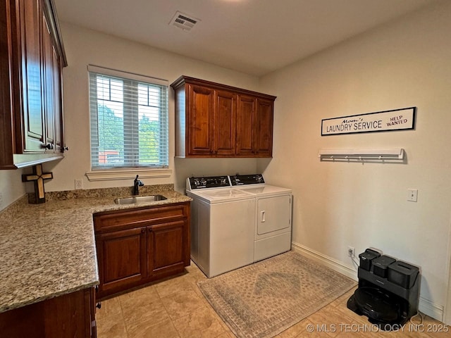 clothes washing area featuring independent washer and dryer, cabinet space, visible vents, and a sink