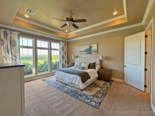carpeted bedroom featuring a raised ceiling, baseboards, visible vents, and ornamental molding