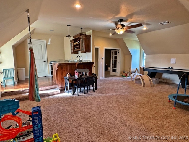 game room with visible vents, carpet floors, a ceiling fan, and vaulted ceiling