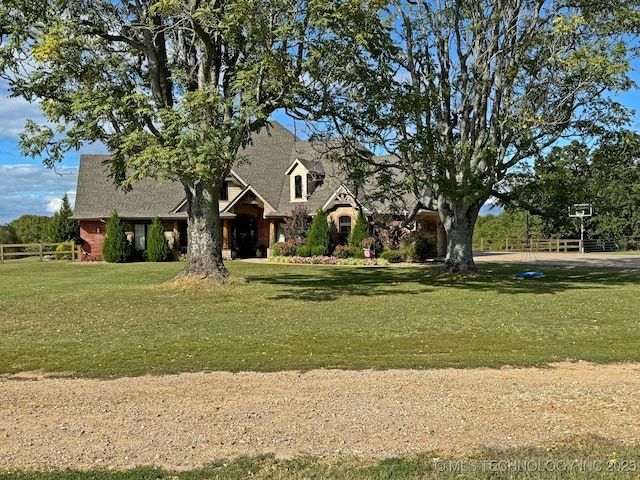 view of front of property with a front yard, fence, and roof with shingles
