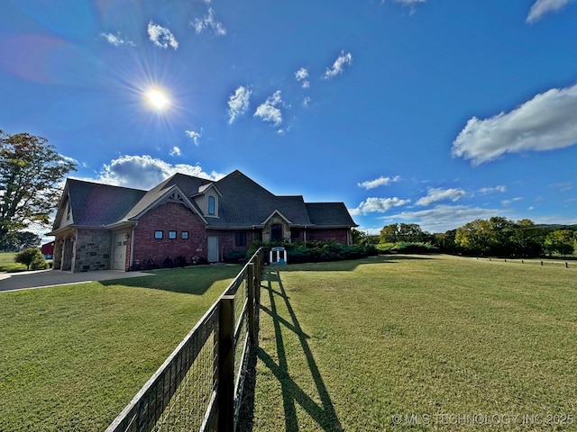 traditional-style home featuring a front lawn, fence, concrete driveway, a garage, and brick siding